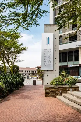 a building with a sign on the side of it at Belina - Crystal Towers Presidential Penthouse in Cape Town