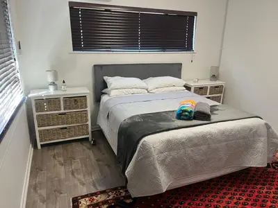 a bedroom with a bed and two night stands at The Elephant Cottage in Cape Town