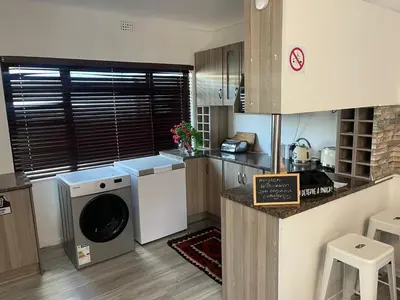 a kitchen with a washer and dryer in a room at The Elephant Cottage in Cape Town