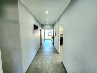 a hallway with white walls and a tile floor at Wagenaar Villas in Monte Vista