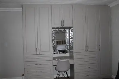a room with white cabinets and a chair and a mirror at Firlands Farmhouse 179A with a view in Sir Lowry Pass