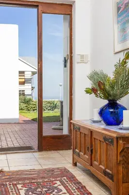 an open door with a blue vase on a wooden cabinet at Casa Familia in Hermanus