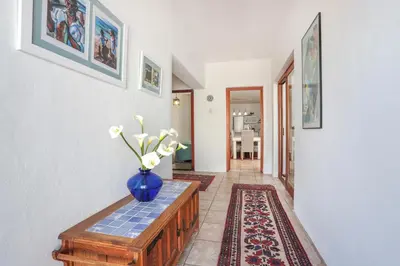 a vase of flowers on a table in a hallway at Casa Familia in Hermanus