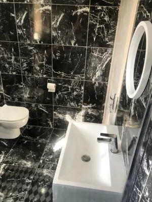 a black tiled bathroom with a sink and a toilet at Comfort and Style in Cape Town