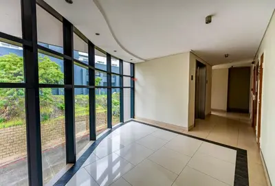 an empty hallway with large windows in a building at Meerendahl Luxury Apartments at Tyger Lake in Cape Town