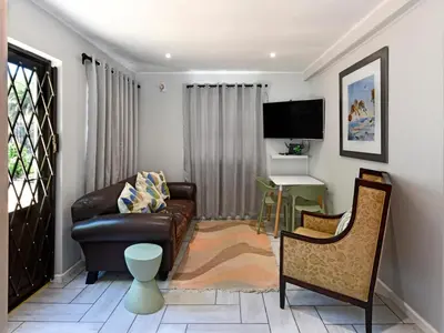 a living room with a couch and a chair at La Rochelle Cottage in Franschhoek