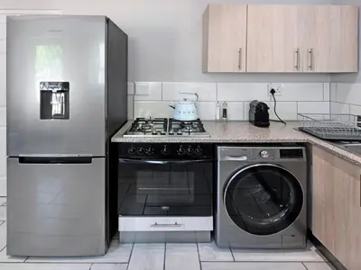 a kitchen with a refrigerator and a stove and a dishwasher at La Rochelle Cottage in Franschhoek
