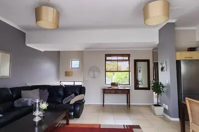 a living room with a black couch and a table at Waterside Townhouse in Cape Town