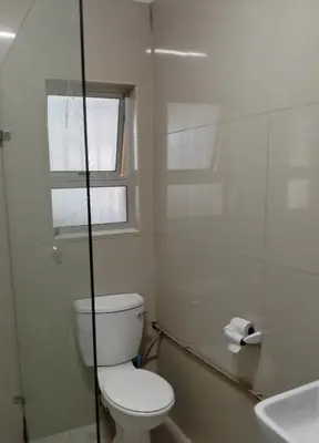 a bathroom with a toilet and a window and a sink at Harmony Lawson Road in Cape Town