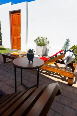 a table and a bench on a patio at Spacious beachfront Townhouse w garage, Blouberg in Bloubergstrand