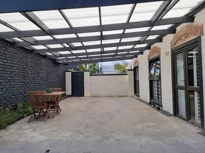 a patio with awning and a table and chairs at @5 on Lincoln in Cape Town