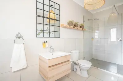 a white bathroom with a toilet and a sink at Avemore Manor House wood fired hot tub magical views and full Backup power in Stellenbosch