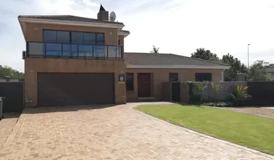a brick house with a garage in a yard at Durbanville Luxury Living Private Room in Durbanville
