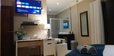 a hotel room with a bed and a tv on the wall at Durbanville Luxury Living Private Room in Durbanville