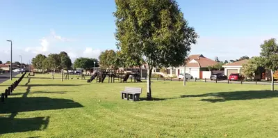 a park with a tree and a bench in the grass at Durbanville Luxury Living Private Room in Durbanville