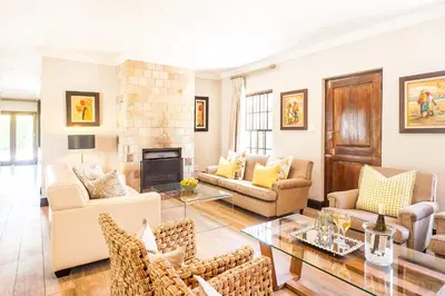 a living room with furniture and a fireplace at Evertsdal Guesthouse in Durbanville
