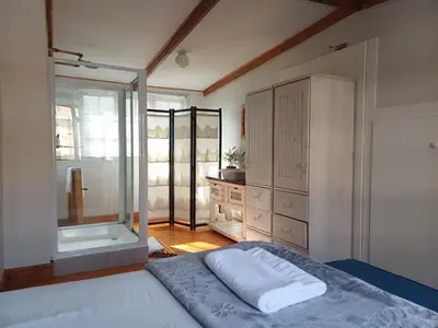 a bedroom with a bed and a glass shower at Loddey's Guesthouse by Beach Collection Winelands in Strand
