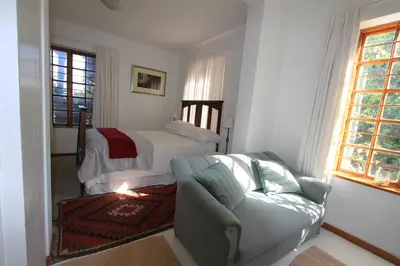 a living room with a couch and a bed at Haven of Peace and Garden Cottage in Hermanus