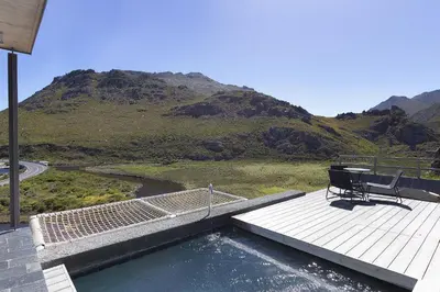 a bench on a deck with a view of a mountain at Hytte Riverview in Rooiels