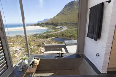 a bathroom with a shower with a view of the ocean at Hytte Riverview in Rooiels