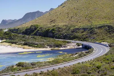 a bridge over a river next to a mountain at Hytte Riverview in Rooiels