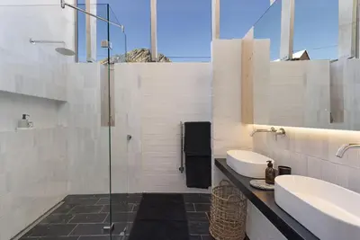 a bathroom with a glass shower and a sink at Hytte Riverview in Rooiels