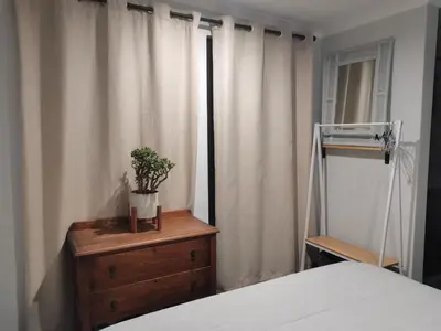 a bedroom with a bed and a dresser with a plant on it at Ruach 5 in Cape Town