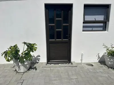 a black door on a white house with plants at Ruach 5 in Cape Town