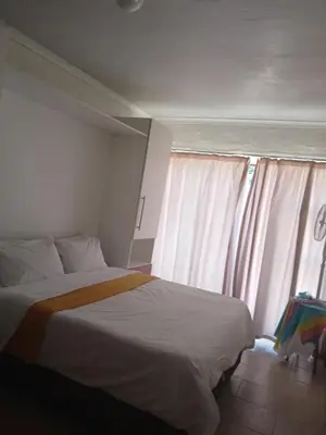 a bedroom with a bed and a window at Stay at Gabby's- no loadshedding in Cape Town