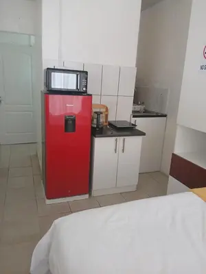 a small kitchen with a microwave on top of a red refrigerator at Stay at Gabby's- no loadshedding in Cape Town