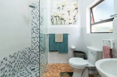 a bathroom with a shower and a toilet and a sink at Apartment in Milnerton close to Woodbridge Island in Cape Town