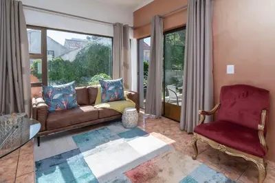 a living room with a couch and a chair at Apartment in Milnerton close to Woodbridge Island in Cape Town