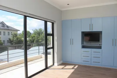 a kitchen with white cabinets and a large window at Pearl Valley Golf Lodge - loadshedding free in Simondium