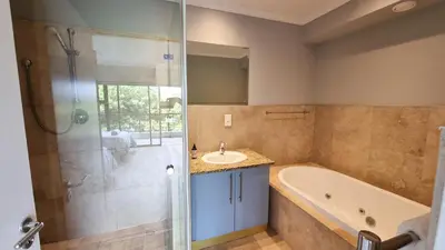 a bathroom with a tub and a sink and a shower at Pearl Valley Golf Lodge - loadshedding free in Simondium