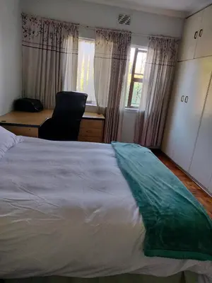 a bedroom with a large white bed and a desk at Near Grandwest in Cape Town