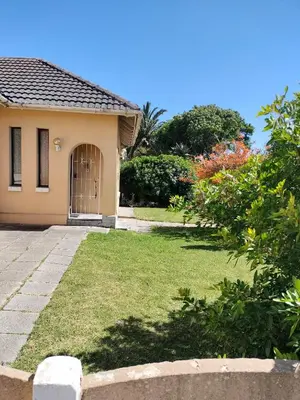 a house with a grass yard with a door at Near Grandwest in Cape Town