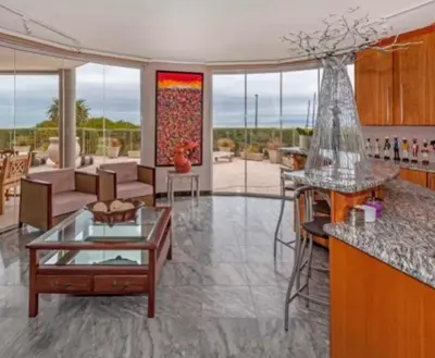 a kitchen and living room with a table and a couch at Villa Georgia in Cape Town