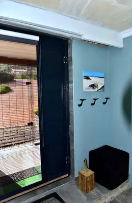 a blue wall with a door with a sign on it at Seaview on 2822 Happy Whale Cottage in Bettyʼs Bay