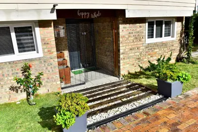 a brick building with stairs leading to the front door at Seaview on 2822 Happy Whale Cottage in Bettyʼs Bay