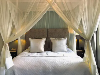 a bedroom with a canopy bed with white pillows at Dunstone Estate in Wellington