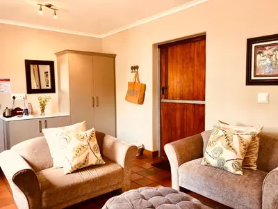 a living room with two chairs and a door at Dunstone Estate in Wellington