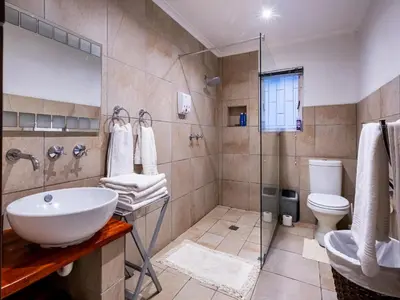 a bathroom with a sink and a toilet and a shower at Belcharto Accommodation in Stellenbosch
