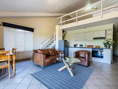 a living room with a couch and a table at Belcharto Accommodation in Stellenbosch