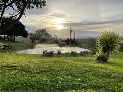 a pond in a field with the sun in the background at Belcharto Accommodation in Stellenbosch