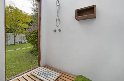 a room with a window with a shower and a bench at Voelklip Beach Cottage in Hermanus
