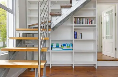 a staircase in a house with a book shelf at Voelklip Beach Cottage in Hermanus