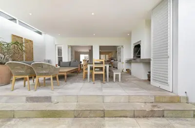 a living room and dining room with a table and chairs at Voelklip Beach Cottage in Hermanus