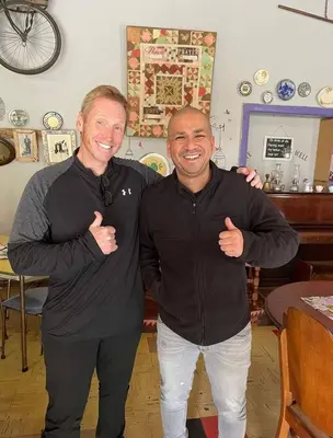 two men standing next to each other with their thumbs up at Suzies Huis Restaurant Bed and Breakfast in Cape Town