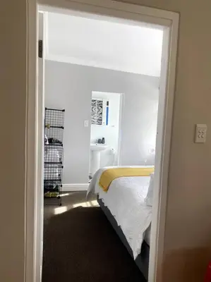 a bedroom with a bed in a room with a window at Milner Cottage: Digital Nomad Oasis in Cape Town