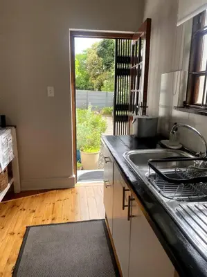 a kitchen with a sink and a counter top at Milner Cottage: Digital Nomad Oasis in Cape Town